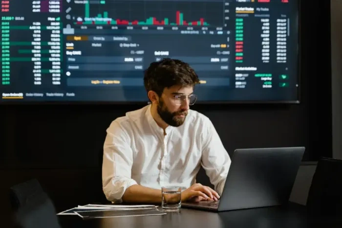 Analis pemasaran muda mempelajari grafik di laptop untuk mengembangkan keterampilannya.