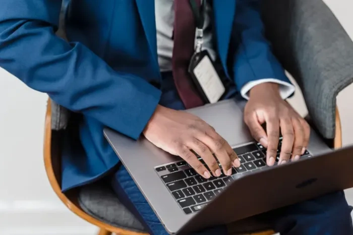 Profesional muda menulis email kerja di laptop