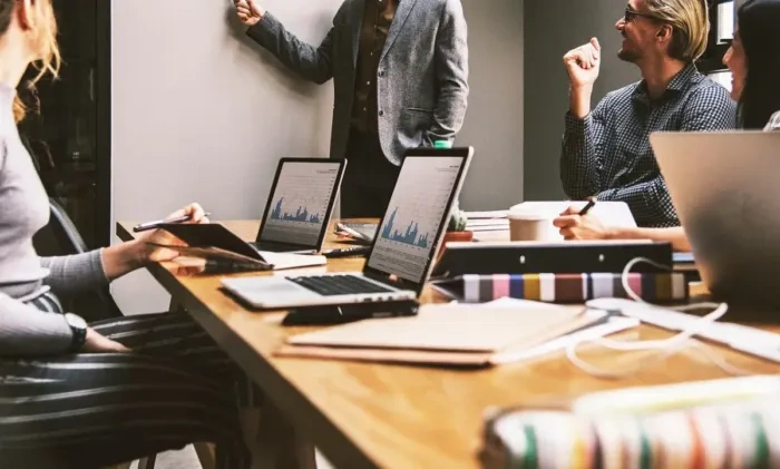 Profesional berdiskusi dengan pemilik usaha kecil tentang kebutuhan bisnis