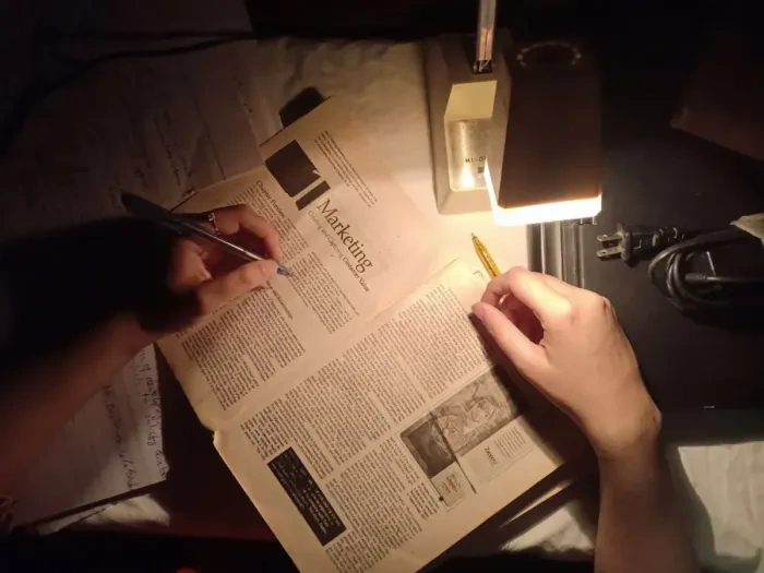 Hand outlining article on notebook before starting to write.