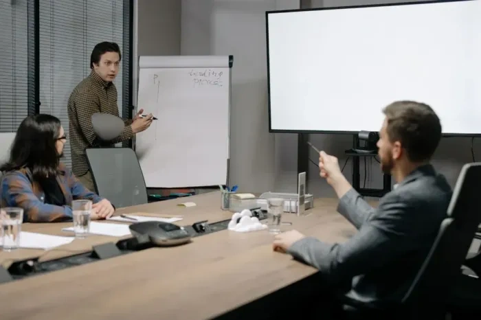 Professional explaining project results to colleagues during a small meeting