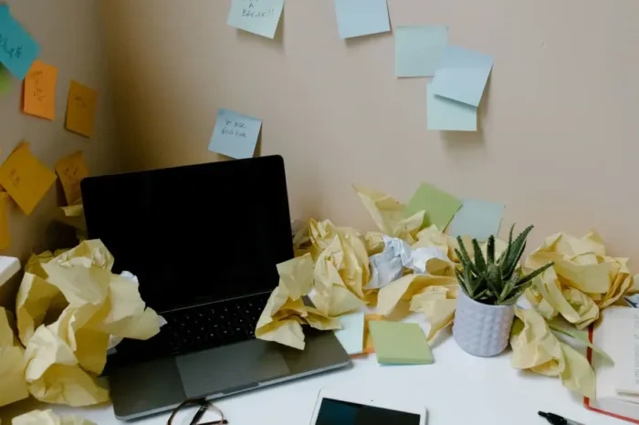 Young worker sorting through ideas at a desk before setting priorities