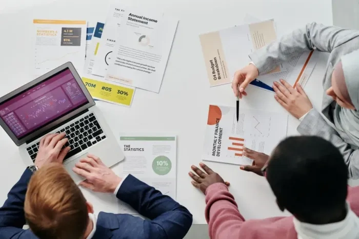 Analis data membahas laporan penjualan bersama rekan kerja