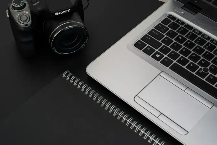 A professional blogger working at a desk with a laptop and notebook
