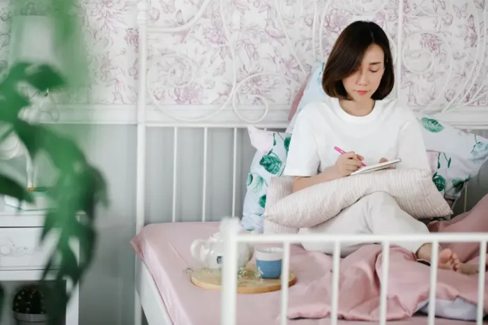 Profesional muda menulis prioritas hidup di buku catatan